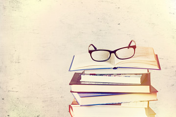 a pile of books and eyeglasses