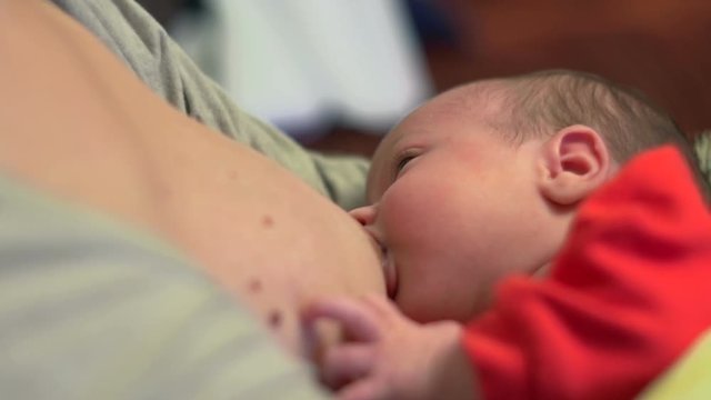 Beautiful one month old baby sucking milk - breastfeeding
