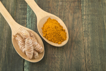 Turmeric roots on wooden background