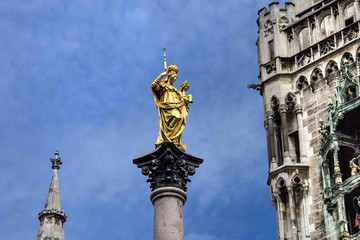 Fototapeta na wymiar Marienplatz, Munich, Germany: Golden figure of the Marian column with parts of the New Town Hall in the background