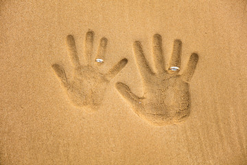 Love handprint with wedding ring on the sand © A ST