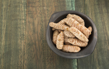Turmeric roots on wooden background