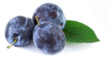 Organic plums fruit with leaf on white. Closeup.