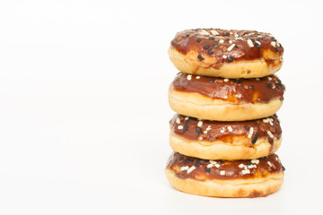 A stack of donuts with chocolate icing and sprinkles on an isolated, white background.