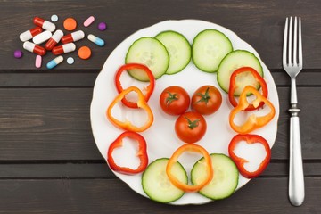 diet and supplements on a wooden table. Strict diet meals. Slimming diet. Tomatoes and pills.
