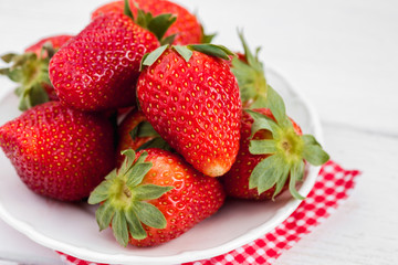 strawberry on the plate on wooden background