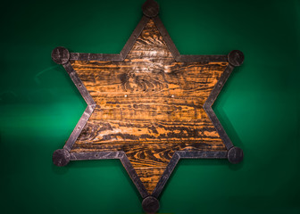 Wooden Sheriff Star on green wall