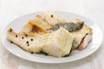 boiled cod fish with black pepper on white plate