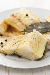 boiled fish with black pepper on white plate