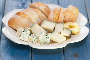 cheese with bread on white dish on blue background
