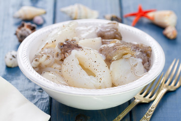 seafood in white plate on blue wooden background