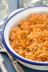 rice with seafood in dish with glass of white wine on blue background