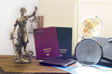 Law concept, statue, magnifying glass, passport and world map. Travel