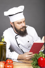 Young chef in uniform reading a recipe