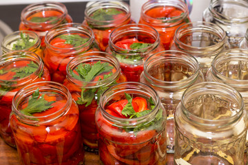 Fototapeta na wymiar Pickled red sweet peppers in a glass jar