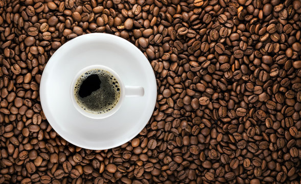 Coffee cup with roasted beans background © evilwata