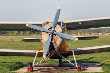 Old vintage plane. Retro airplane. Vintage single-engine plane with a propeller. Old biplane. Front view, with the side of the fuselage.