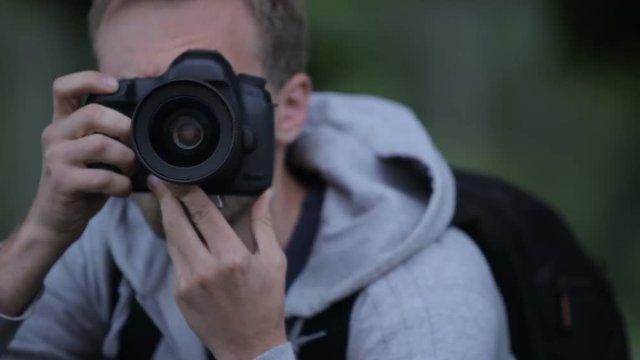 Young Man Taking Pictures At A Professional Digital SLR Camera
