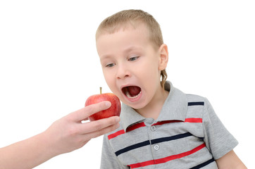 Boy eats an apple on a white background