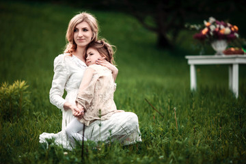 A mother and child in nature. The little girl clung to the mother. The concept of life values, peace, security and love