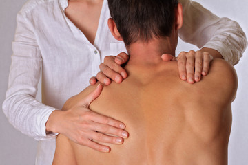 Chiropractic, osteopathy, physical therapy. Therapist  doing healing treatment on man's back....