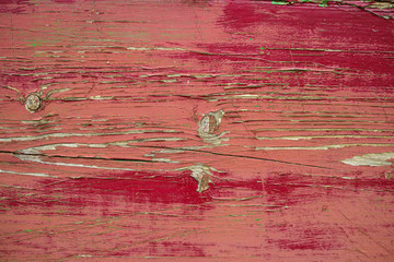 Old red paint layer on textured wooden planks