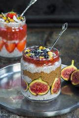 Chia seed pudding layered with fruit, almond butter and strawberry sauce