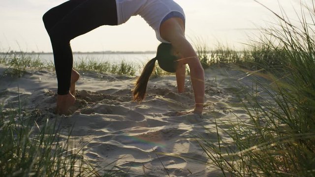 4K Flexible young female in a one legged upward bow yoga pose, in slow motion