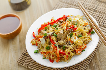 Asian food. Fried rice noodles with tofu, vegetables and shiitake mushroom. Oriental cuisine meal. Close-up.