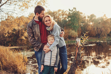 happy family spending time together outdoor. Lifestyle capture, rural cozy scene. Father, mother and son walking in forest