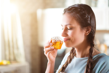 Delighted woman eating maffyn