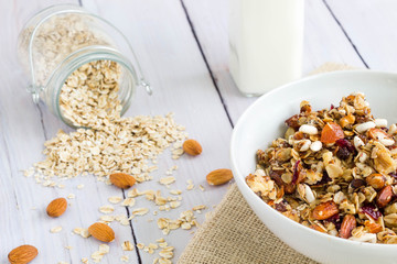 Granola with a glass of milk and a jar of oat in the background