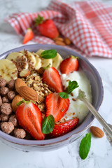 smoothie in a bowl for breakfast with yogurt, strawberries, oatm