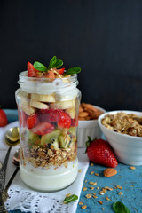 Oatmeal with yogurt, kiwi, banana, strawberries and almonds in a