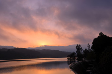 Obraz premium Landscape of reservoir and mountains at twilight sunset.
