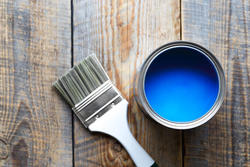 painting at home with can blue paint on wooden background