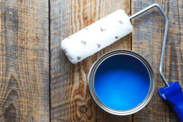 painting at home with can blue paint on wooden background