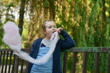 une petite fille manger une barbe à papa