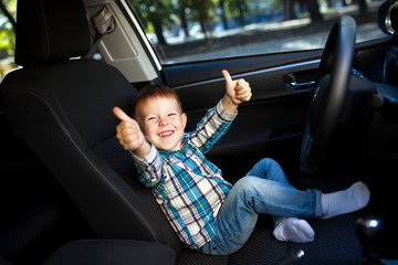 Cute little boy driving fathers car