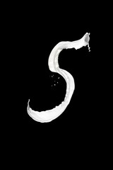 Number 5 made of milk, isolated on black
