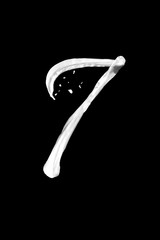 Numbers 7 made of milk, isolated on black