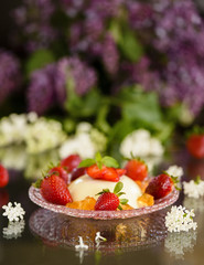 Italian dessert pannacotta with strawberries and lilac flowers