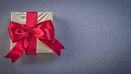 Present box wrapped in glittery paper on grey background holiday