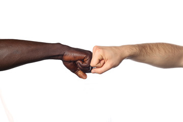 Fototapeta premium deux poings l'un contre l'autre entre deux hommes de couleurs différentes