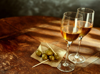 Glasses of Wine on Wood Table with Green Olives