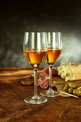 Glasses of Wine, Cured Meat and Olives on Table