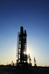 Obraz premium The silhouette of oilfield derrick