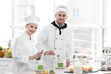 Male and female chefs working at kitchen