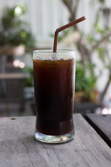 A glass of black iced coffee.