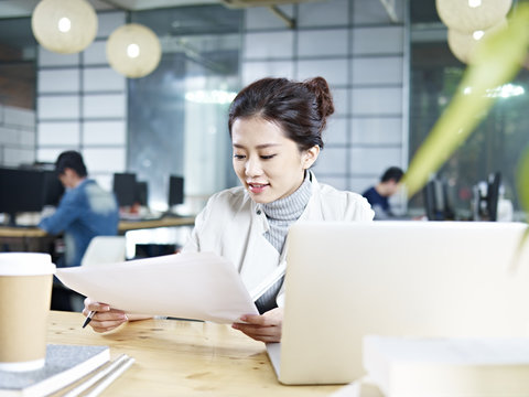 young asian business woman working reading a report in office